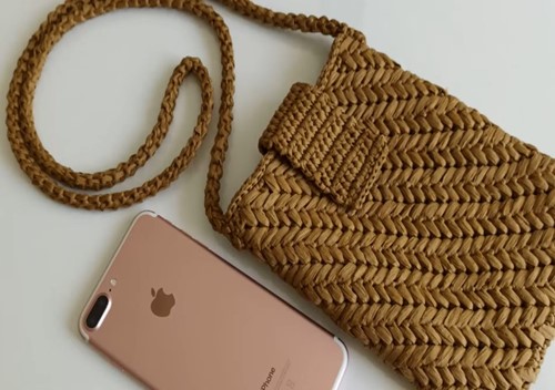 Telefonla birlikte ölçüsü karşılaştırılan başak desenli rafya çanta modeli