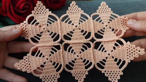 Bitmiş tığ işi dantel motif, elde tutulurken yakından gösterilmiş