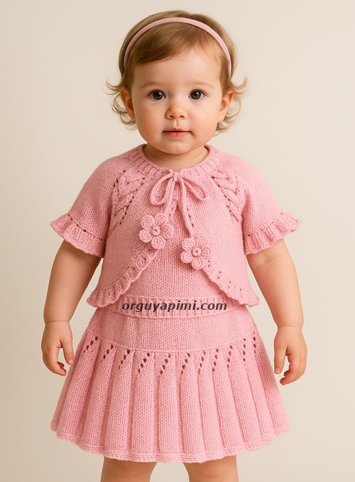 2 yaş kız bebek pembe örgü takımı giymiş – pileli fırfırlı etek ve burgulu bolero modelin orijinal hali.