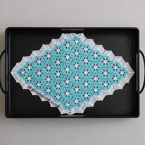 Altıgen dantel motifi ile hazırlanmış, siyah metal tepsi üzerinde motifli dantel modeli